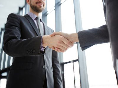Handshake of successful business partners in formalwear after making agreement